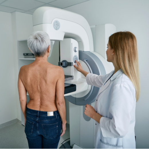 Mujer mayor realizándose una mamografía digital con la asistencia de una doctora en un centro de diagnóstico.
